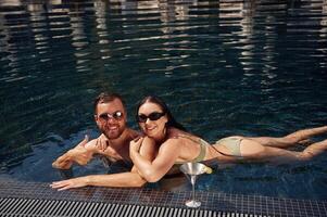 Enjoying the swimming. Man with woman is in the pool together photo