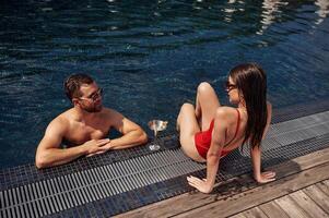 Man, with woman is in the pool together photo