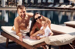 Conception of ,vacation. Happy, family of father, mother and son are in the pool photo