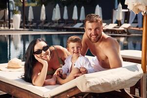 Conception, of vacation. Happy family of father, mother and son are in the pool photo