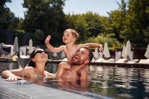 Having fun., Happy family of father, mother and son are in the pool photo