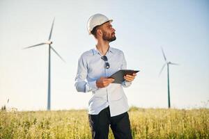 Front view. Service engineer is on the field with windmills photo