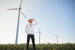 Front view.. Service, engineer is on the field with windmills photo
