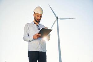 Front,, view. Service engineer is on the field with windmills photo