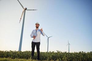 Front ,view. Service engineer is on the field with windmills photo