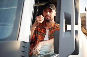 Radio communication., Young truck driver in casual clothes photo