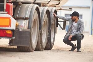 Checking the wheels. Young truck ,drive,r in casual clothes photo