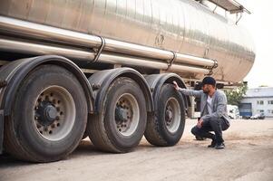 Checking the ,wheels. Young truck driver in casual clothes photo