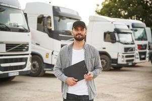Black colored, notepad in hands. Young truck driver in casual clothes photo