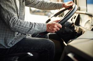 Close up ,view, sitting ,inside. Young truck driver in casual clothes photo