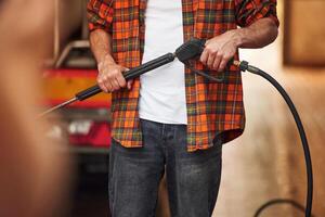 Man, is washing the vehicle. Young truck driver in casual clothes photo