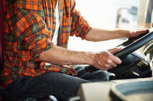 Close up view, ,sitting inside. Young truck driver in casual clothes photo