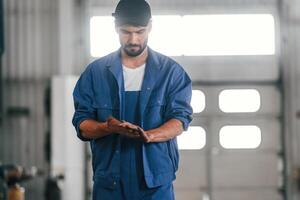 After the job done, standing. .Auto mechanic working in garage. Repair service photo