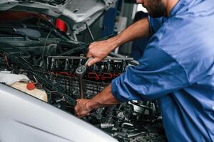 Close up view.. Auto mechanic working in garage. Repair service photo