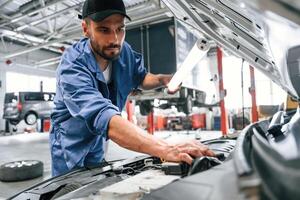 Troubleshooting process.. Auto mechanic working in garage. Repair service photo