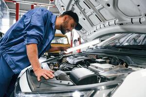 Troubleshooting, process. Auto mechanic working in garage. Repair service photo