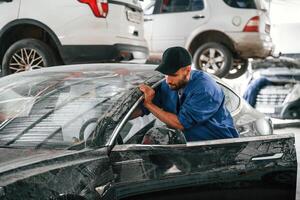 Dirty, car is moved by auto mechanic that is in garage. Repair service photo