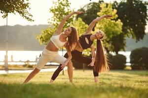 Conception, of sport.. Two women are doing exercises outdoors on the field photo