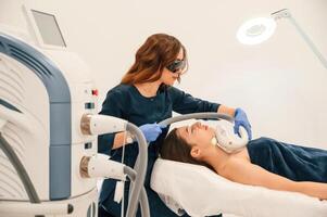 Woman ,is getting LPG, hardware massage in beauty salon. Getting photo rejuvenation procedure at cosmetology clinic