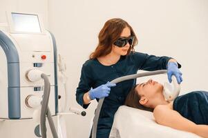 Woman ,is, getting LPG hardware massage in beauty salon. Getting photo rejuvenation procedure at cosmetology clinic