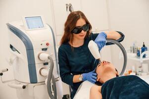 Lying down.. Getting photo rejuvenation procedure at cosmetology clinic