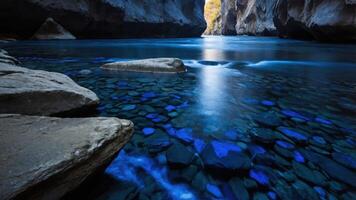 A serene river flows through a narrow canyon, with rocks and blue water creating a tranquil scene. photo