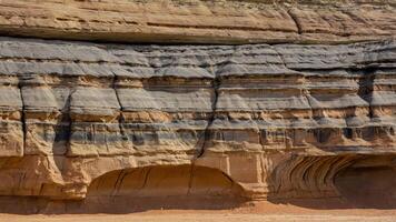 A close-up view of layered rock formations showcasing geological textures and colors. photo
