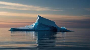 A majestic iceberg reflects in calm waters under a colorful sky at dusk. photo
