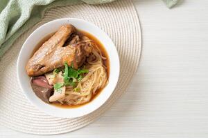 Braised duck noodles with brown soup. photo