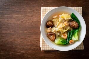 pork dumpling soup with shrimps and vegetable on dark background photo
