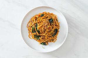 Stir Fried Spaghetti with Clam and Chilli Paste on white plate - fusion food style photo