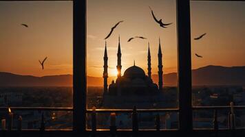 Viewing Mosque Silhouette at Sunset Through Window with Birds Flying photo