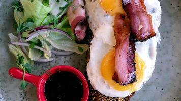 Delicious breakfast. fried eggs and bacon with fresh greens and sauce video
