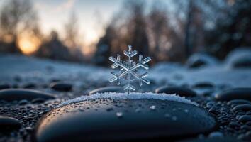 Delicate Snowflake Resting on Pebble with Winter Sunset Backdrop photo
