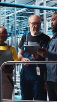 vertical inteligente fábrica equipe líder e colegas implemento automatizado fluxos de trabalho e ao controle sistemas, informatizando manual operações. colegas de trabalho integrar sensores para dentro transportador cintos, Câmera uma video