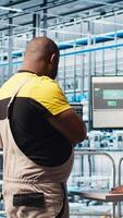 Vertical Smart photovoltaics factory staff members brainstorming, looking at system performance metrics. Solar panels plant colleagues discussing, tracking energy production through IoT sensors, camera A video