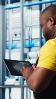 Vertical Photovoltaic smart factory engineer uses tablet to design production lines for assembly facility in CAD program. Industry 4.0 solar panels plant worker uses device to optimize floor layouts, camera A video