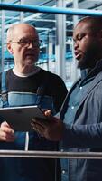 Vertical Manager overseeing smart factory, giving instructions to engineers testing automated systems. Industry 4.0 industrial plant supervisor tasking employees with identifying bottlenecks, camera A video