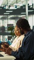 Vertical Cheerful supervisor congratulating employee for good work. Happy manager in office pleased after seeing good key performance indicators, doing high five with worker, camera B video
