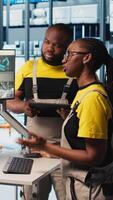 Vertical Experienced team leader doing induction to new trainees in industry 4.0 photovoltaics plant. Senior engineer in smart solar panels factory teaching interns to maximize power generation, camera A video