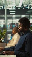 Vertical Employee in office receiving project paperwork from management, starting work on new project. Manager giving tasks to worker, providing necessary documents folder, camera B video