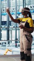 vertical indústria 4,0 industrial plantar engenheiro usando virtual realidade para ao controle automatizado maquinaria, garantindo fluxo de trabalho continuidade. inteligente fábrica técnico gerencia robótico braços usando vr equipamento, Câmera uma video