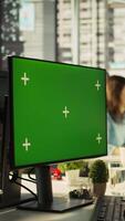 Vertical Man in office reviewing financial graphs on green screen PC, analyzing key performance indicators. Employee looking over data trends and strategic insights on chroma key computer, camera B video