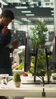 Vertical Employee arriving in office, looking over revenue figures on documents. Accountant in office starting job shift, comparing company statistical numbers, working hard to finish tasks before deadline video