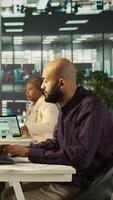 Vertical Manager giving company bookkeeper business documents to read and verify accuracy Employee analyzing company information records provided by supervisor in office, camera B video