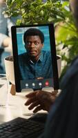 Vertical Worker in office talking with manager supervising tasks progression during online videocall. Employee discussing with supervisor overseeing work done during remote teleconference meeting, , camera A video