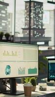 Vertical Modern workspace with analytical data paperwork documents in bright office environment with potted plants. Tablet on desk with digital statistics charts displayed on screen, panning shot video