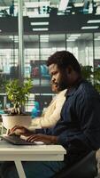 Vertical Employee in office leaving desk to present revenue figures on tablet. Accountant finishing project task of comparing company statistical numbers on device, going to present data, camera B video