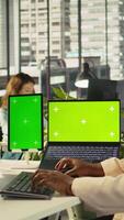 Vertical Mockup tablet and laptop in office used by employee working on company administrative tasks. Chroma key devices on desk used by worker reviewing business data metrics, camera B video