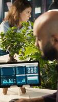Vertical Accountant in office inputting financial figures on PC, giving report files to coworkers. Arab man in workplace crosschecking data on computer, giving documents to colleagues, camera A video